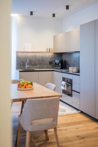 a kitchen with a table with a bowl of fruit on it at Apartament Tre Cime in San Sigismondo