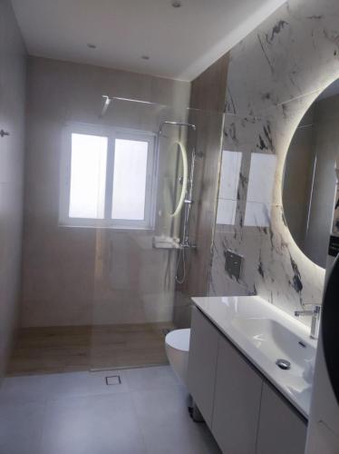 ein Badezimmer mit Waschbecken, Toilette und Spiegel in der Unterkunft Urban Elegance in Larisa