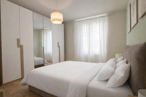 a white bedroom with a large white bed with pillows at Casa Camelia in Scarperia