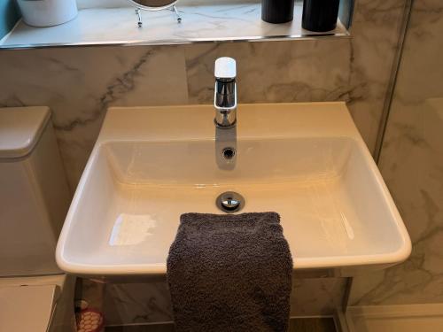 a bathroom sink with a towel hanging from it at Honeybees Haven in Hunstanton