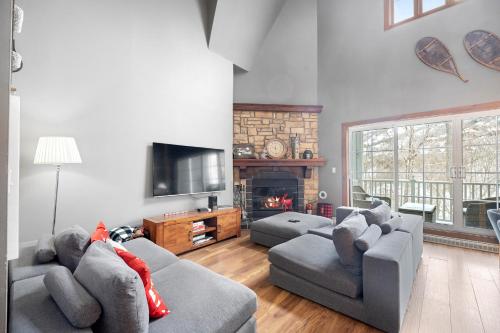 a living room with two couches and a fireplace at Les Manoirs 3bdrs W Pool & Hottub Near Village in Mont-Tremblant