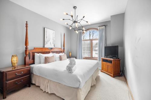 a bedroom with a bed with a teddy bear sitting on it at Les Manoirs 3bdrs W Pool & Hottub Near Village in Mont-Tremblant