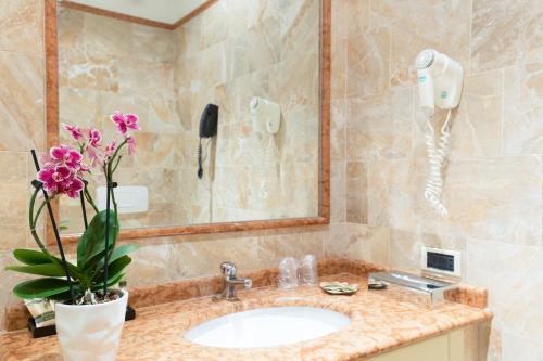 a bathroom with a sink and a phone at Palace Grand Hotel Varese in Varese