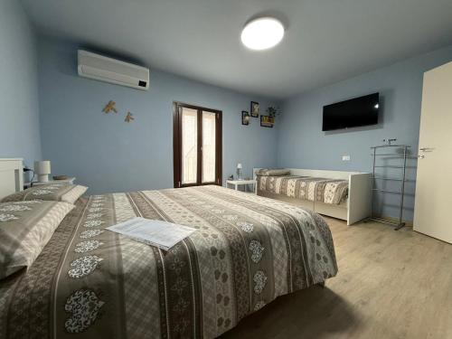 a bedroom with two beds and a tv on the wall at Re-Start in Scandolara Ravara