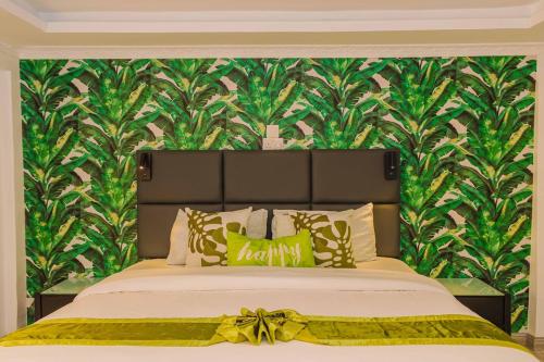 a bedroom with a large bed with a green wall at Chic Modern Studio Apartment with Pool in Nanyuki