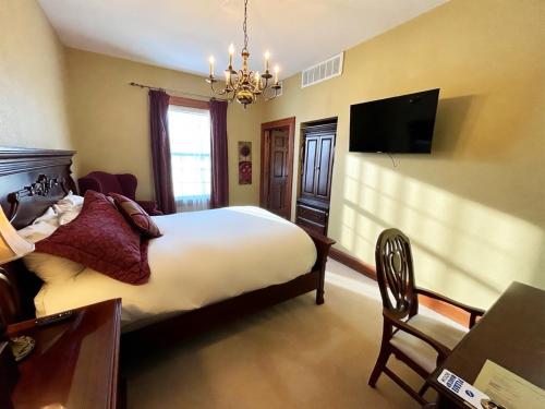 a bedroom with a bed and a flat screen tv at The Port Hotel in Port Washington