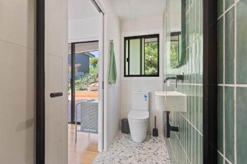 a bathroom with a toilet and a sink at Sun Kissed - As close as you get to Pambula Beach in Pambula Beach