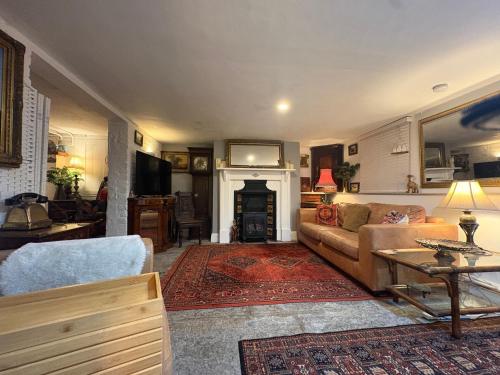 a living room with a couch and a fireplace at Historic Charm Garden Flat Adjoining Central Park in Taunton
