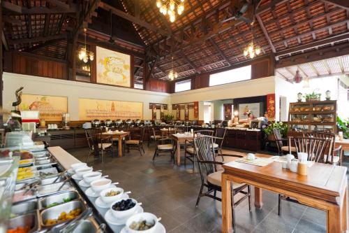 a dining room with tables and chairs in a restaurant at Khaolak Bhandari Resort & Spa in Khao Lak