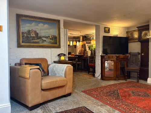 a living room with a couch and a television at Historic Charm Garden Flat Adjoining Central Park in Taunton