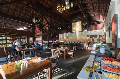 a restaurant with tables and people sitting at tables at Khaolak Bhandari Resort & Spa in Khao Lak