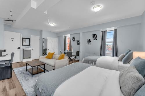 a bedroom with two beds and a living room at Guestic Hotel at Queen West in Toronto