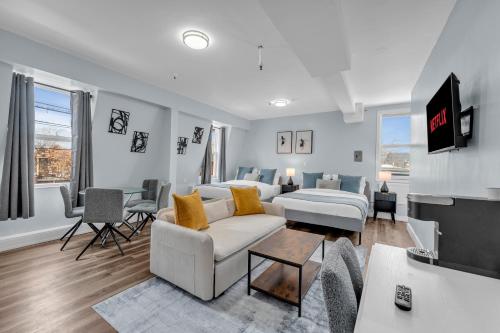 a living room with a couch and a room with a tv at Guestic at Queen West in Toronto