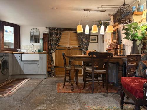 a kitchen with a table and chairs in a room at Historic Charm Garden Flat Adjoining Central Park in Taunton