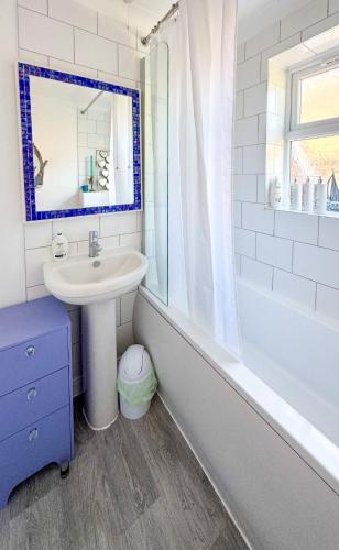 a bathroom with a sink and a tub and a mirror at The Sashes - Cozy Apartment - FREE Parking - Ultrafast WIFI - Smart TV - Netflix - sleeps up to 6! Close to Poole Town Center & Sandbanks & Bournemouth in Poole