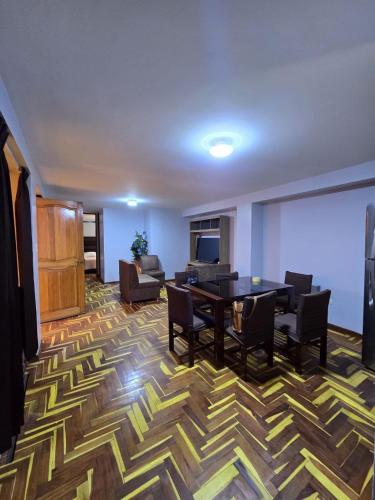 a living room with a dining table and chairs at Candela Apartment PUNO in Puno