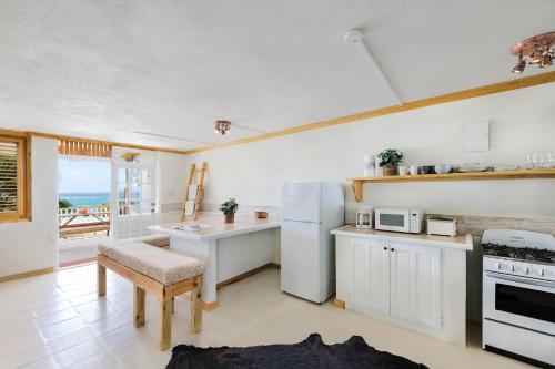 Una cocina con un refrigerador blanco y una mesa. en Surfers Bay, en Christ Church