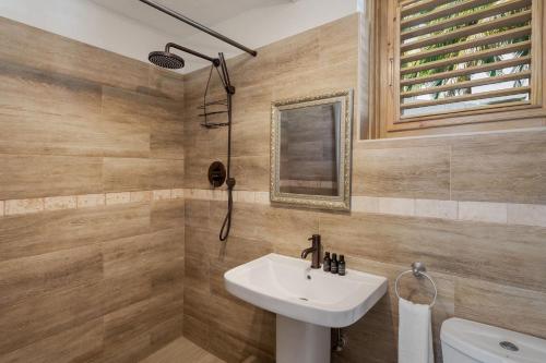 un baño con lavabo y espejo en Surfers Bay, en Christ Church