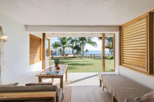 Una sala de estar con una mesa y vista al mar. en Surfers Bay, en Christ Church