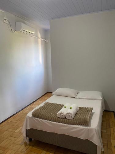 a bedroom with a bed with two towels on it at Hotel Linassi in Cruz Alta