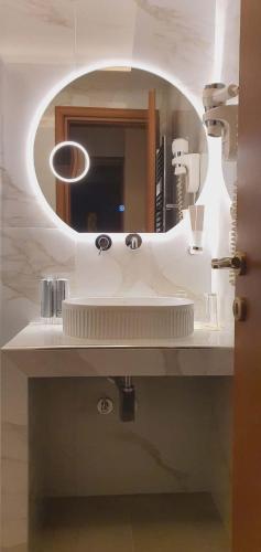 a bathroom with a white sink with a mirror at Xenios Dias Boutique Hotel in Litochoro