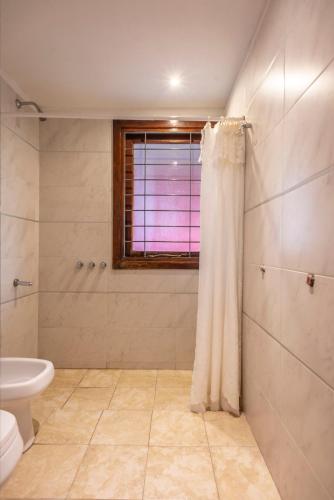 a bathroom with a toilet and a window at Cabañas Cambados in Villa Gesell