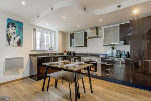a kitchen with a wooden table and a dining room at Luxury 2 Bed 2 Bath Canary Wharf Apartment with Balcony in London