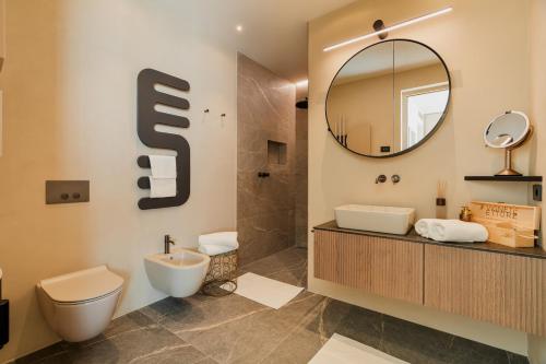 a bathroom with a toilet and a sink and a mirror at Villa Vallonga in Bardolino