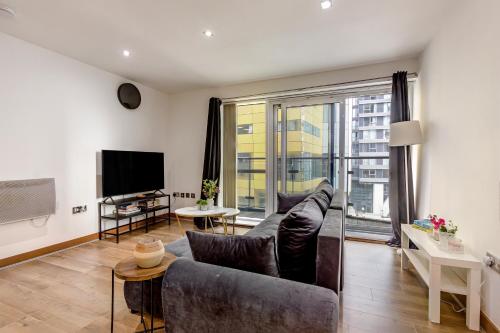 a living room with a couch and a tv at Luxury 2 Bed 2 Bath Canary Wharf Apartment with Balcony in London
