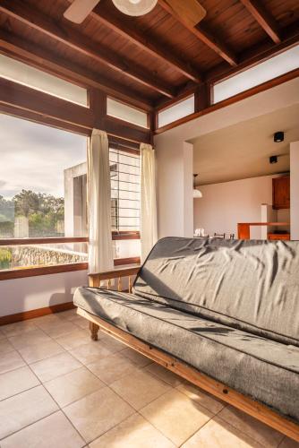 a bedroom with a bed and a large window at Cabañas Cambados in Villa Gesell