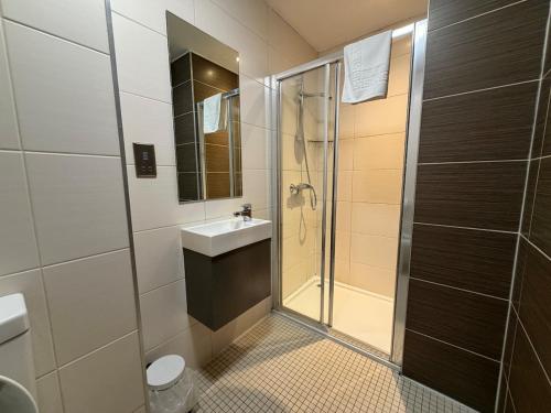 a bathroom with a shower and a sink at HNFC Stays - Harmony Accommodation in Elswick