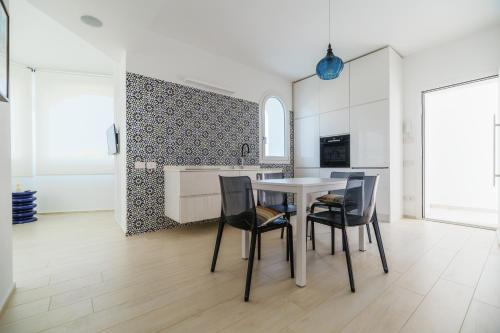 a kitchen and dining room with a table and chairs at Azuleyos Garden & Pool fronte mare in Marcelli