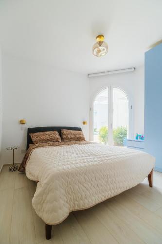 a white bedroom with a large bed and a window at Azuleyos Garden & Pool fronte mare in Marcelli