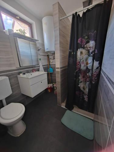 a bathroom with a toilet and a shower curtain at Maja Anna Vendégház in Bogács
