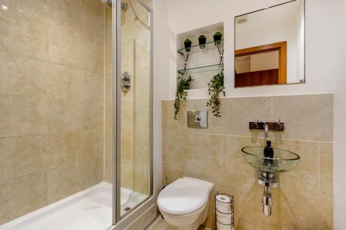 a bathroom with a shower and a toilet and a sink at Luxury 2 Bed 2 Bath Canary Wharf Apartment with Balcony in London
