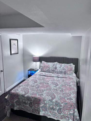 a bedroom with a large bed with a colorful blanket at Bernie's Basement in Milton