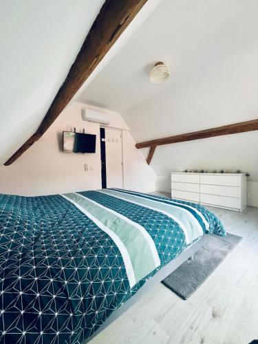 a bedroom with a blue bed in a attic at Maison avec Jacuzzi - Europa-Park in Obenheim