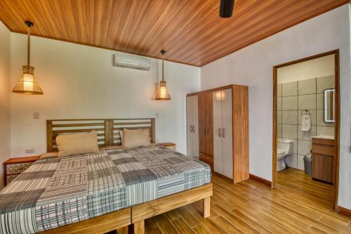 a bedroom with a bed and a bathroom at Beachfront Studio - Direct Beach Access - Fast Wifi & AC in Cocles