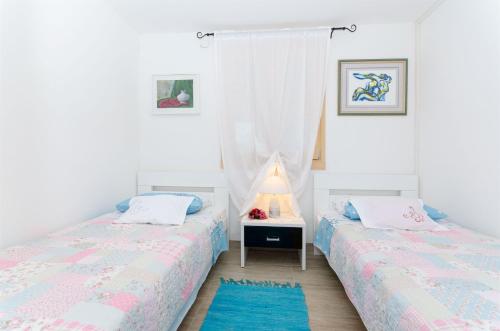 a bedroom with two beds and a window at House Ara in Grohote