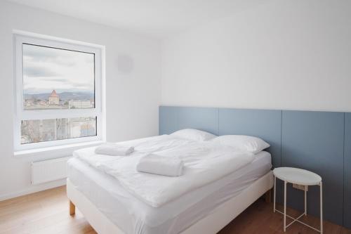 a white bed in a room with a window at Castle view Vinetto apartment with free parking in Trenčín