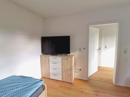 a bedroom with a flat screen tv on a dresser at Wohnung Werratal Blick in Dankmarshausen