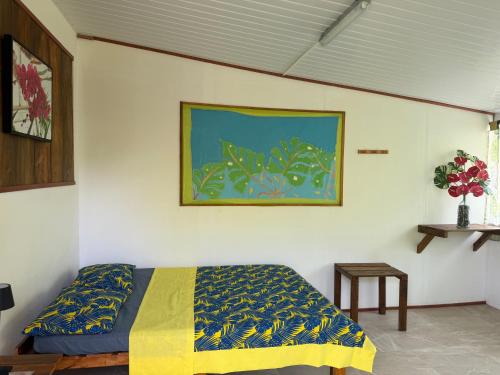 a bedroom with a bed and a painting on the wall at Le KAHAIA Rangiroa Tiputa in Rangiroa
