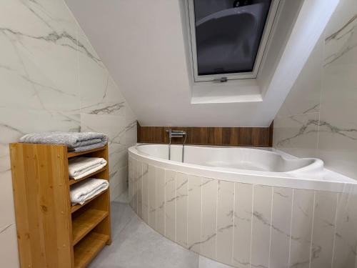 a white bathroom with a tub and a tv at Apartament u Buki Zator, Skawina, Kraków in Pozowice