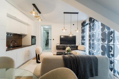 a kitchen and living room with a table and chairs at Liberty Central Apartment in Tuzla