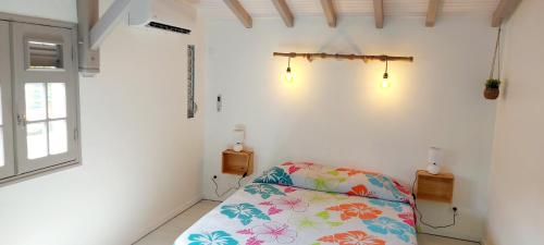 a bedroom with a bed with a flowered pillow at Ti Cactus Guadeloupe in Sainte-Rose