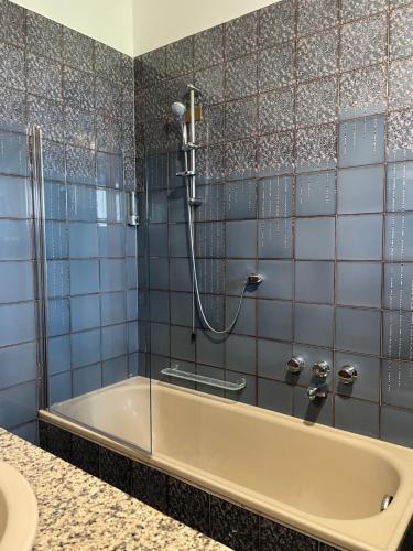 a bath tub in a bathroom with blue tiles at Residenza Ticino in Oleggio