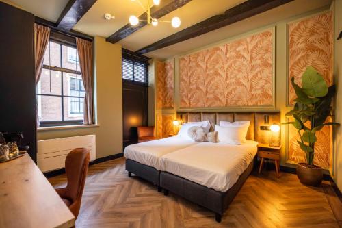 a bedroom with a large bed and a table at Bakery Boutique Hotel in Leeuwarden