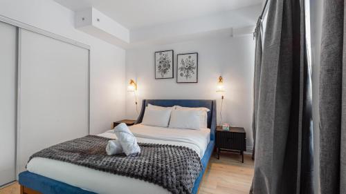 a bedroom with a bed with white sheets and pillows at The Jarvis Suites in Toronto