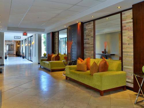a lobby with a yellow couch in a building at Premier Hotel East London ICC in East London