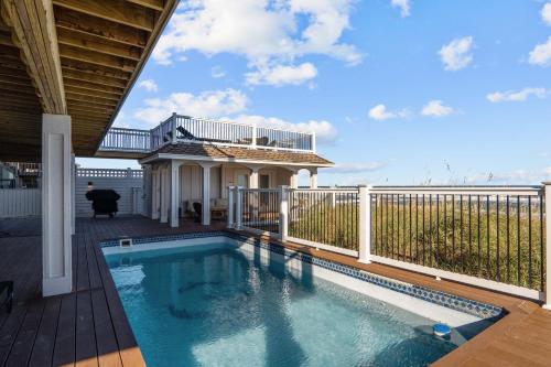 a swimming pool on a deck next to a fence at 2876 - The Blue Martini in Duck